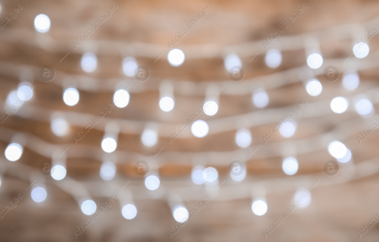 Photo of Blurred view of Christmas lights on color background