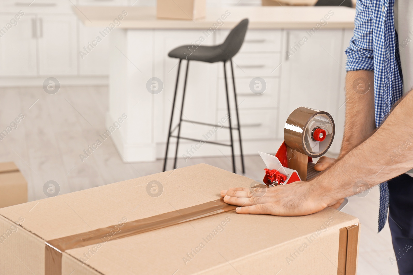 Photo of Man packing moving box indoors, closeup. Space for text