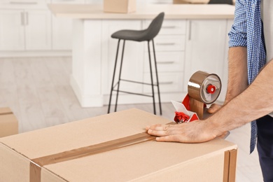 Photo of Man packing moving box indoors, closeup. Space for text