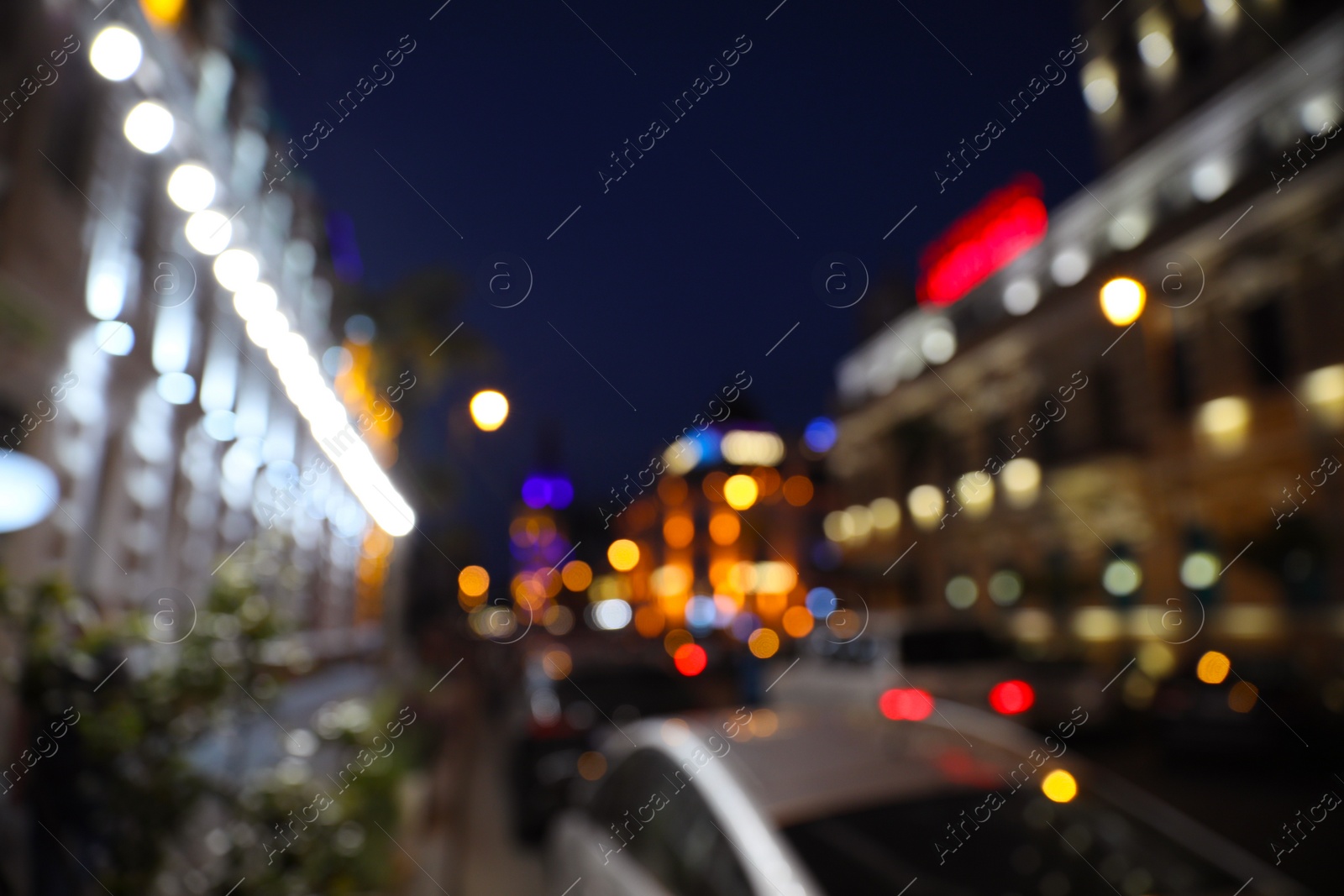 Photo of Blurred view of beautiful cityscape with glowing streetlights and cars at night