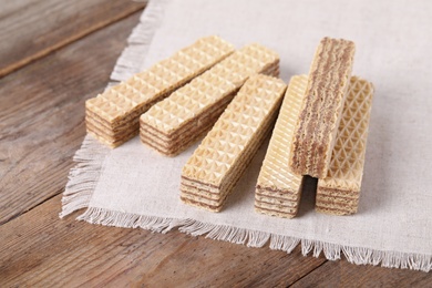 Delicious crispy wafer sticks on brown wooden background