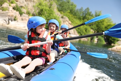 Little children kayaking on river. Summer camp