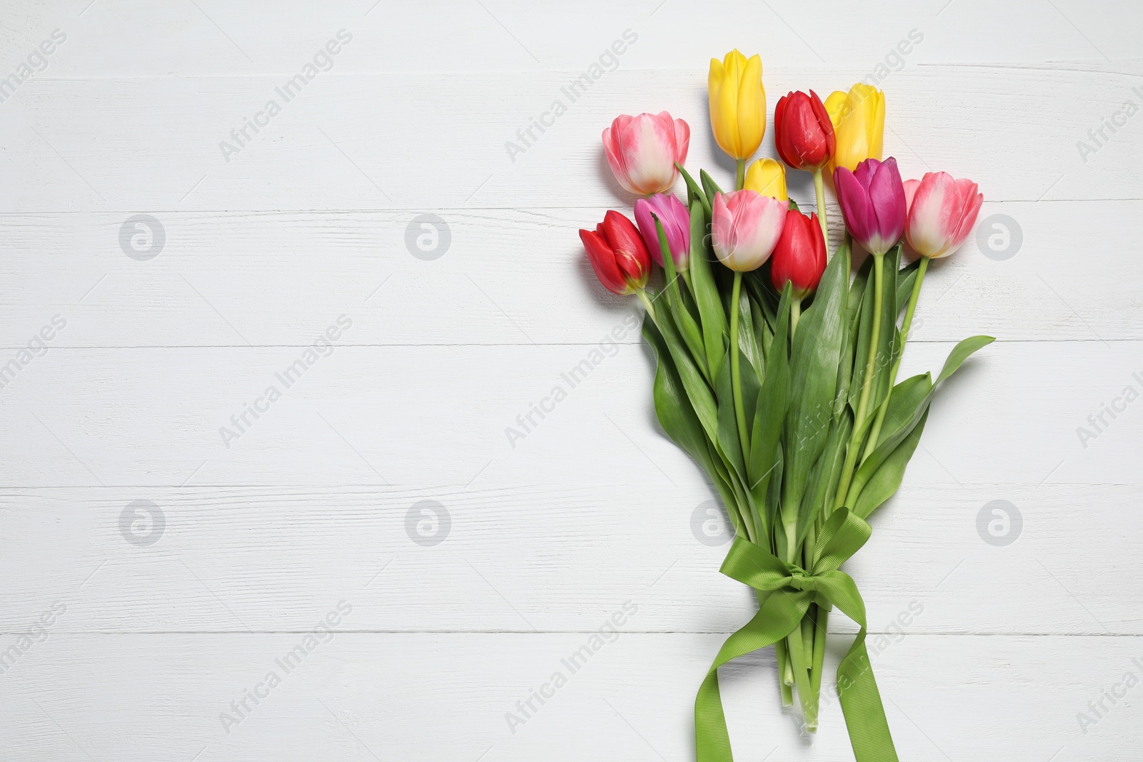 Photo of Beautiful colorful tulips on white wooden background, flat lay with space for text