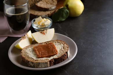Photo of Bread with butter and quince paste served on black table