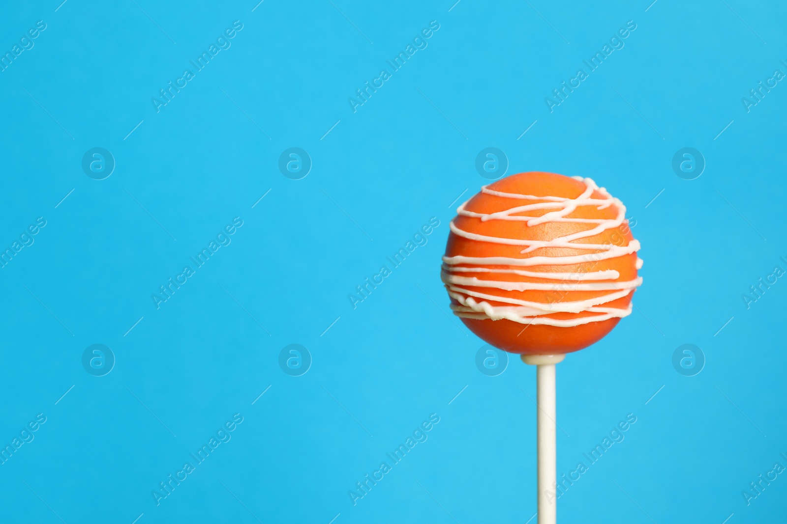 Photo of Bright delicious cake pop on color background. Space for text