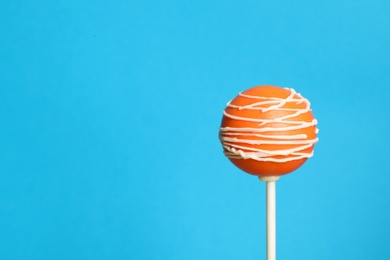 Bright delicious cake pop on color background. Space for text