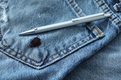 Photo of Pen and stain of black ink on jeans, closeup