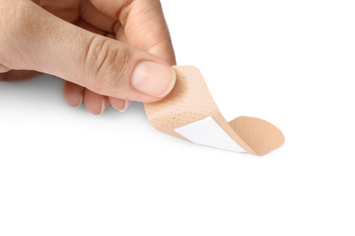 Photo of Woman putting sticking plaster on white background. First aid item