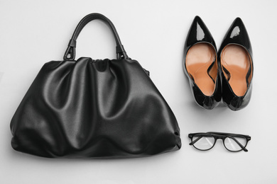 Stylish woman's bag, shoes and glasses on light grey background