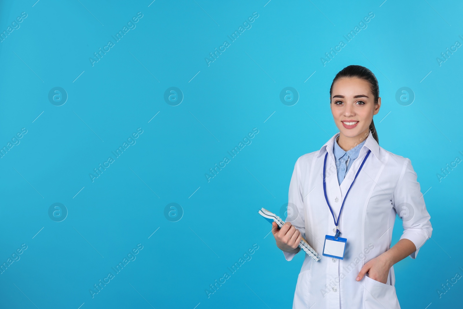 Photo of Young medical student with notebooks on color background. Space for text