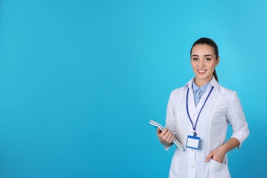 Young medical student with notebooks on color background. Space for text