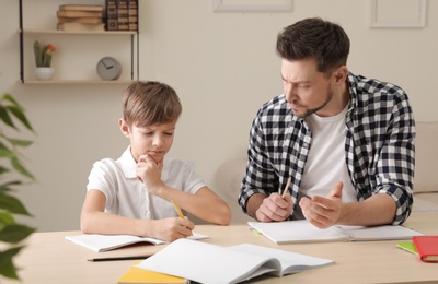Photo of Dad struggling to help his son with school assignment at home