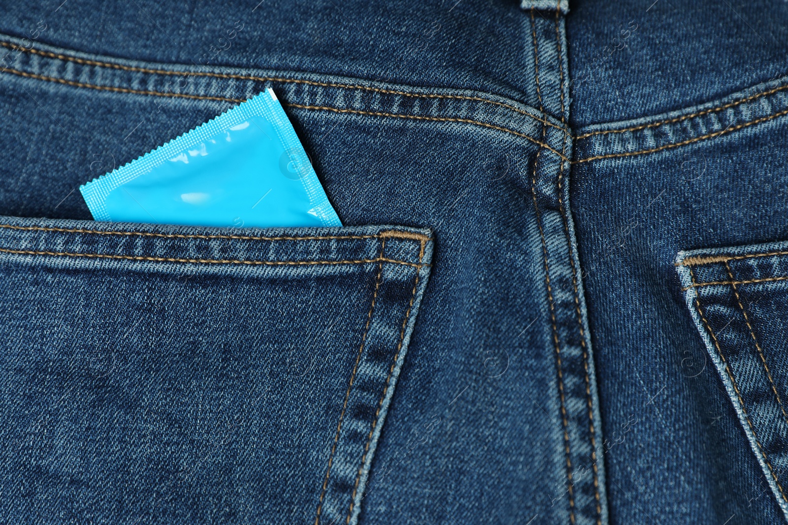Photo of Packaged condom in jeans pocket, closeup. Safe sex