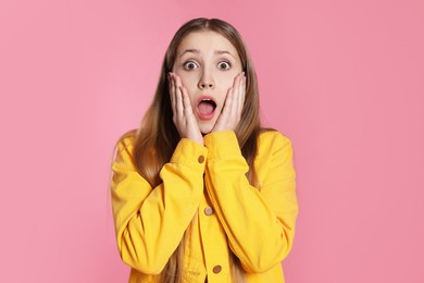 Photo of Portrait of shocked teenage girl on pink background