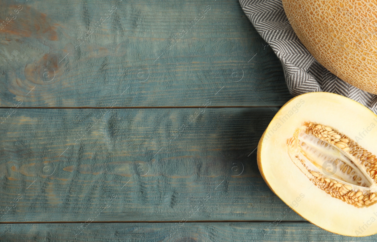Photo of Tasty cut ripe melon on blue wooden table, flat lay. Space for text