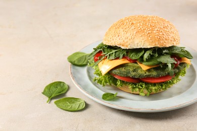 Photo of Tasty vegetarian burger with spinach cutlet, cheese and vegetables on white table, space for text