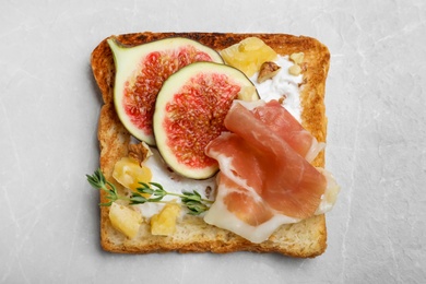 Photo of Delicious sandwich with figs, proscuitto and cheese on light table, top view