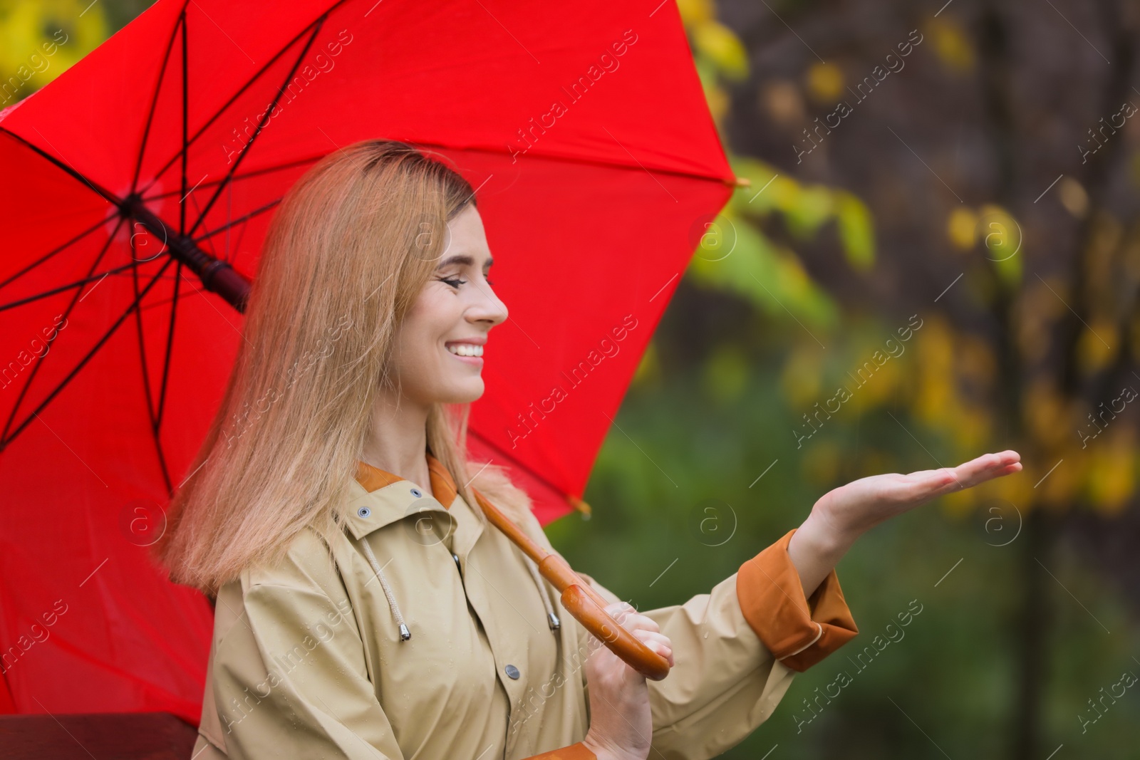 Photo of Woman with umbrella in autumn park on rainy day