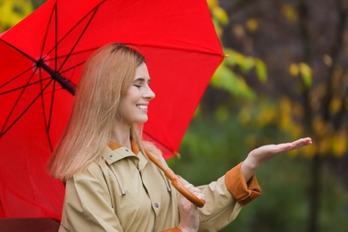 Photo of Woman with umbrella in autumn park on rainy day