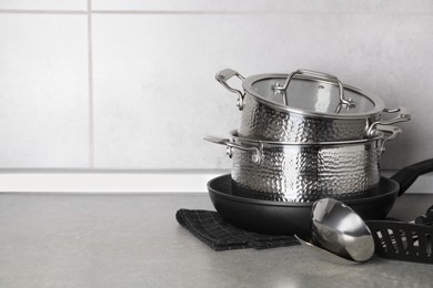 Set of different cooking utensils on grey countertop in kitchen. Space for text