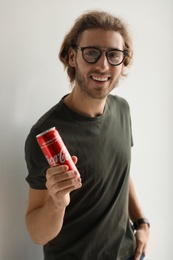 Photo of MYKOLAIV, UKRAINE - NOVEMBER 28, 2018: Young man with Coca-Cola can on white background