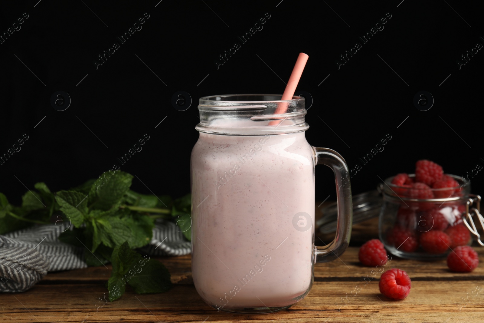 Photo of Tasty milk shake with raspberries and mint on wooden table