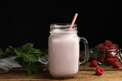 Tasty milk shake with raspberries and mint on wooden table