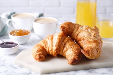 Photo of Tasty breakfast. Fresh croissants and jam on white marble table