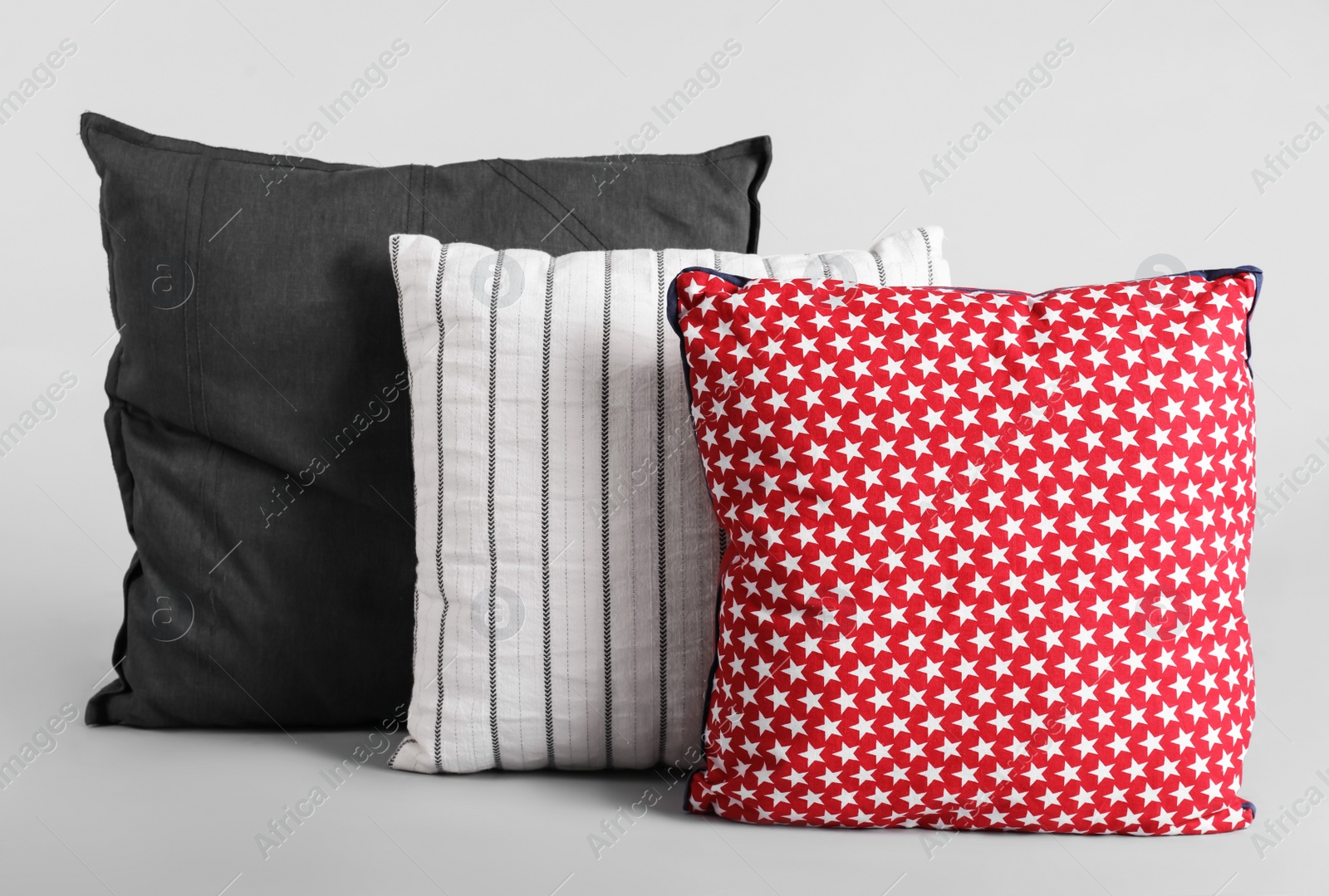 Photo of Different stylish soft pillows on grey background