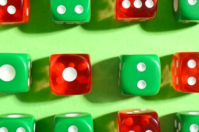 Photo of Many color game dices on green background, flat lay