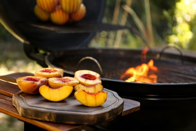 Delicious grilled peaches on wooden table outdoors