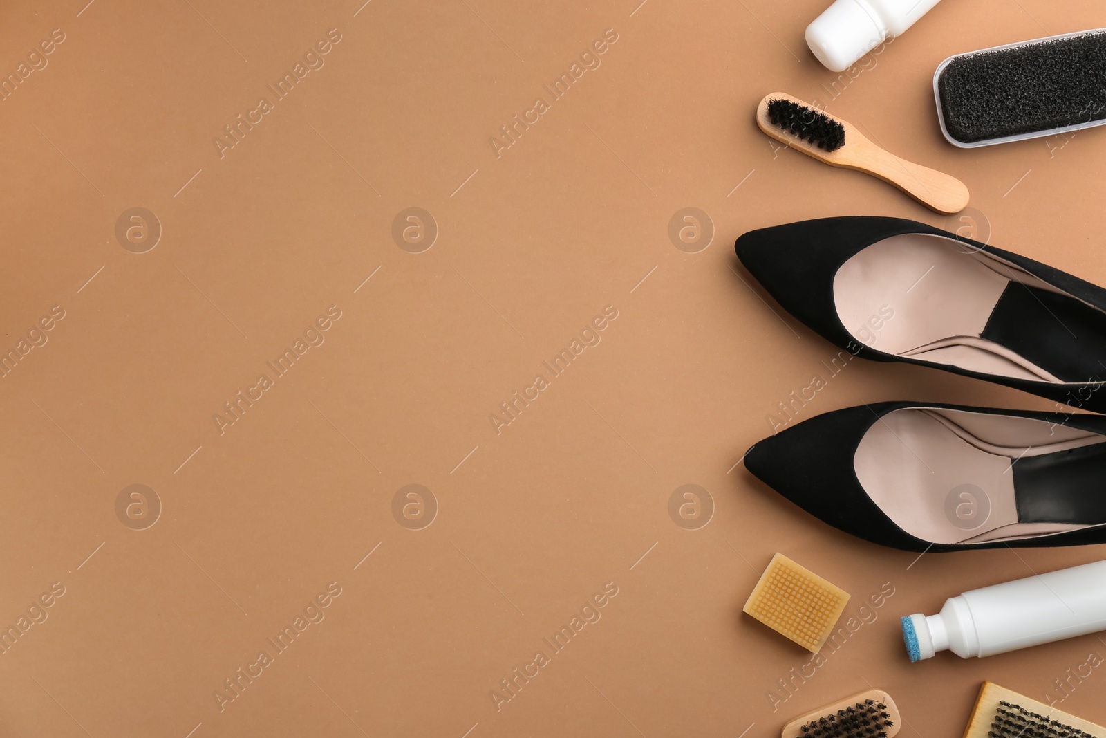 Photo of Stylish footwear with shoe care accessories on brown background, flat lay. Space for text