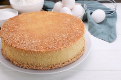 Photo of Plate with delicious sponge cake on white wooden table, closeup