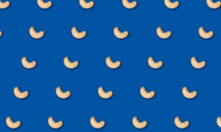 Image of Many tasty cashew nuts on blue background, flat lay