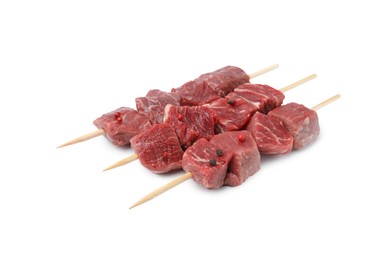 Photo of Wooden skewers with cut fresh beef meat isolated on white