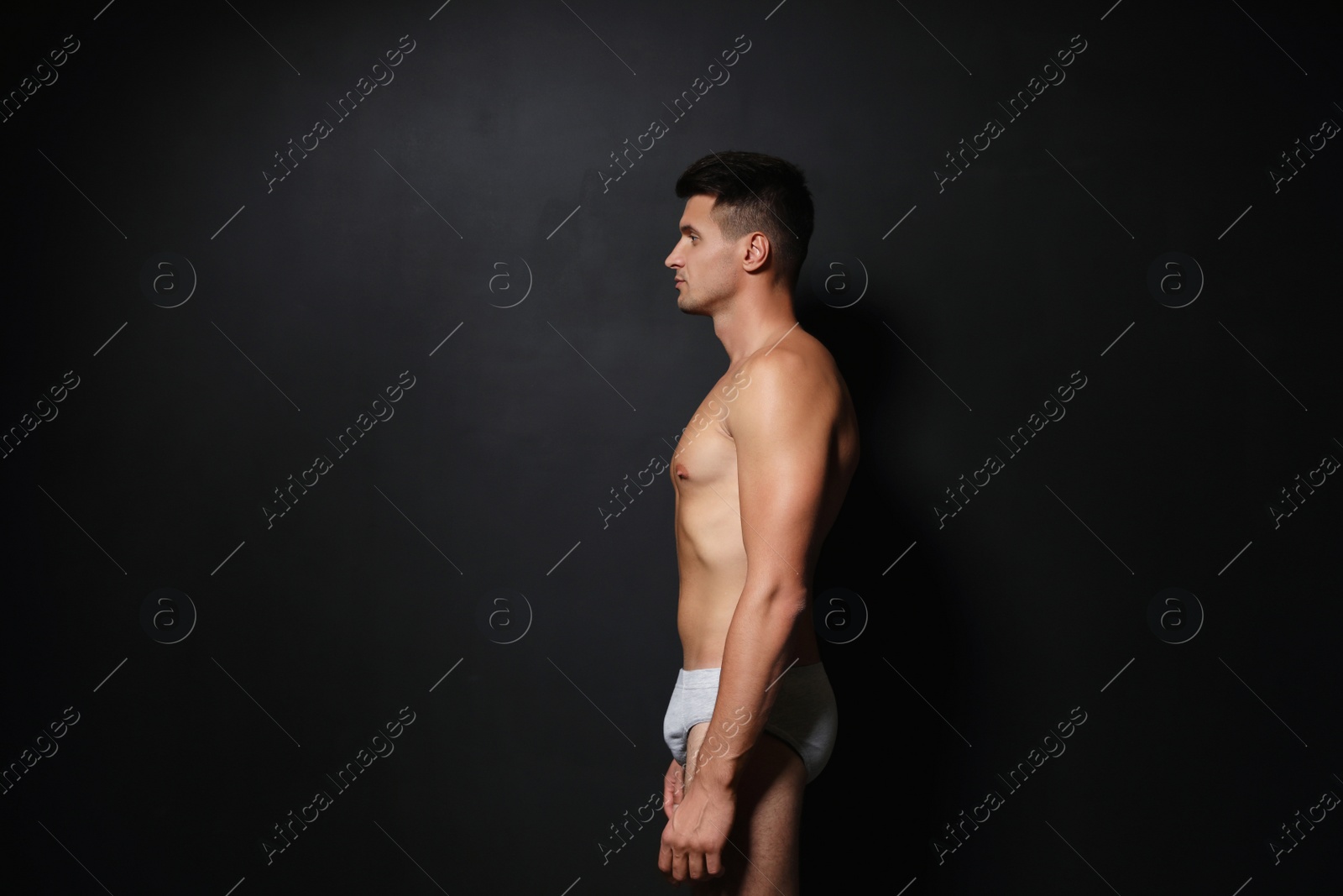 Photo of Handsome man wearing underwear on black background