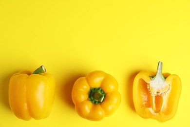 Ripe bell peppers on yellow background, flat lay. Space for text