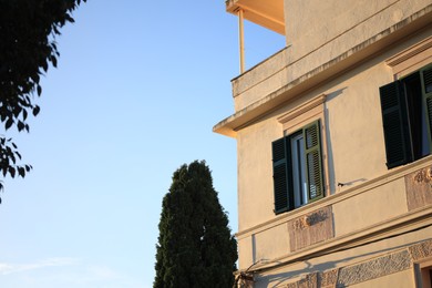 Residential building with wooden shutters on windows under blue sky