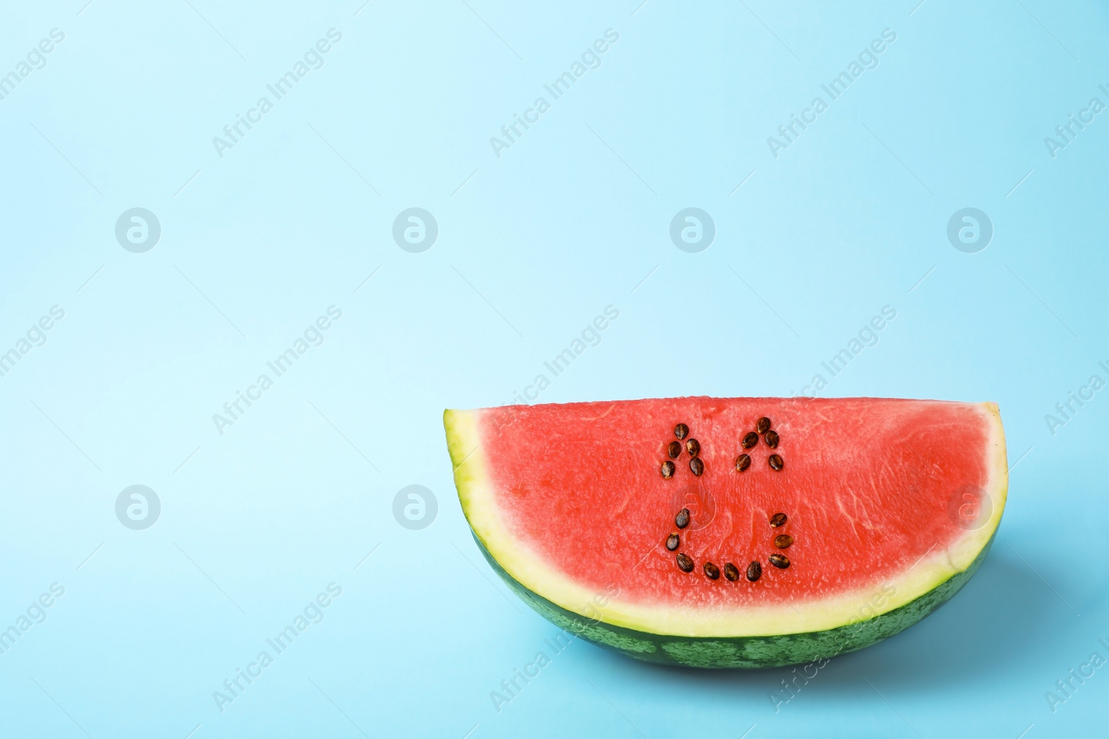 Photo of Watermelon with funny smiling face on color background. Space for text