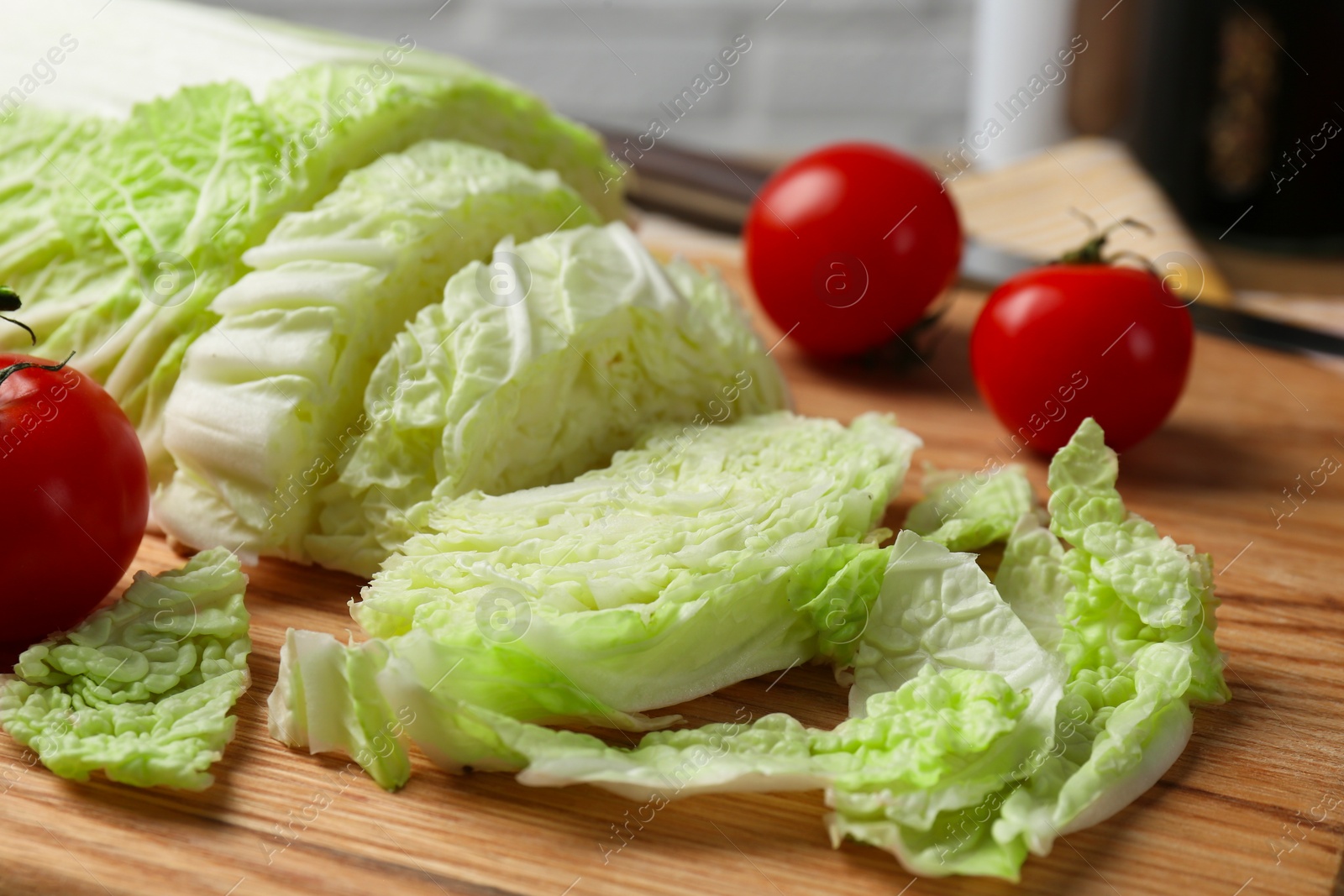 Photo of Cut fresh Chinese cabbage and tomatoes on wooden board, closeup