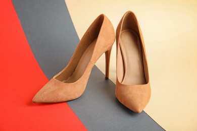 Photo of Pair of beautiful shoes on color background