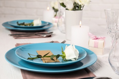 Elegant festive table setting with blank card in restaurant