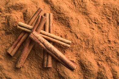 Photo of Aromatic cinnamon powder and sticks, closeup