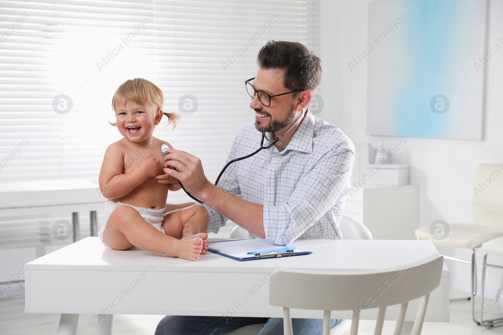 Photo of Pediatrician examining baby with stethoscope in clinic