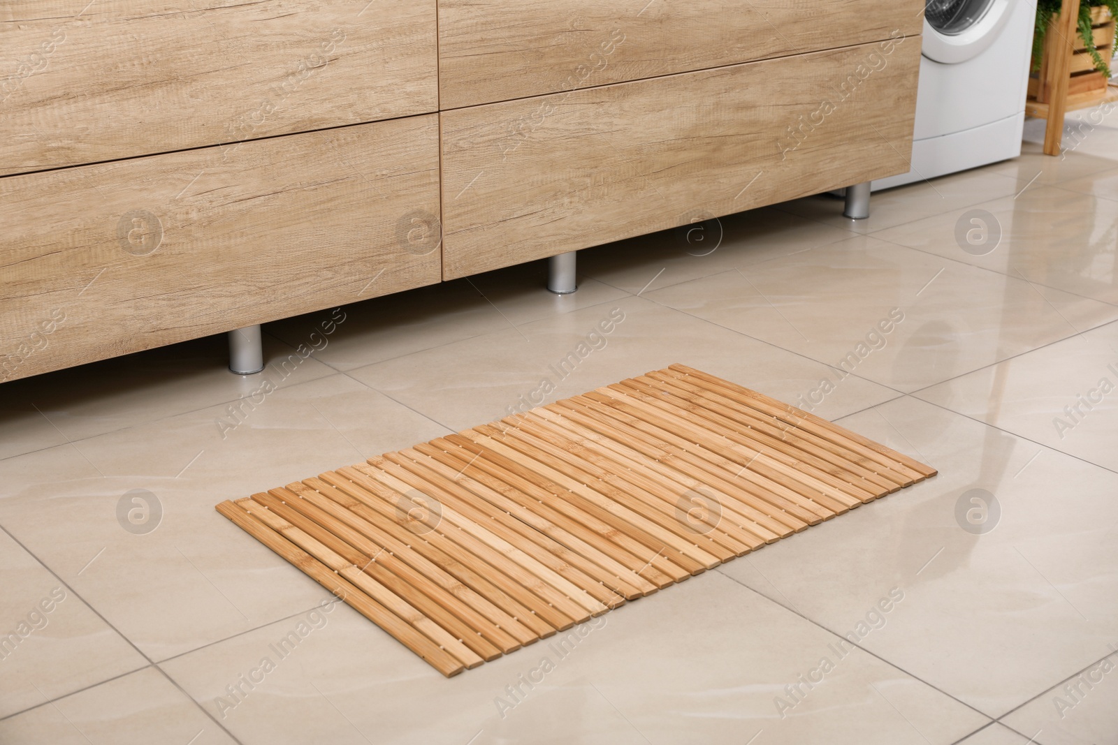 Photo of Wooden mat on floor in bathroom. Interior design