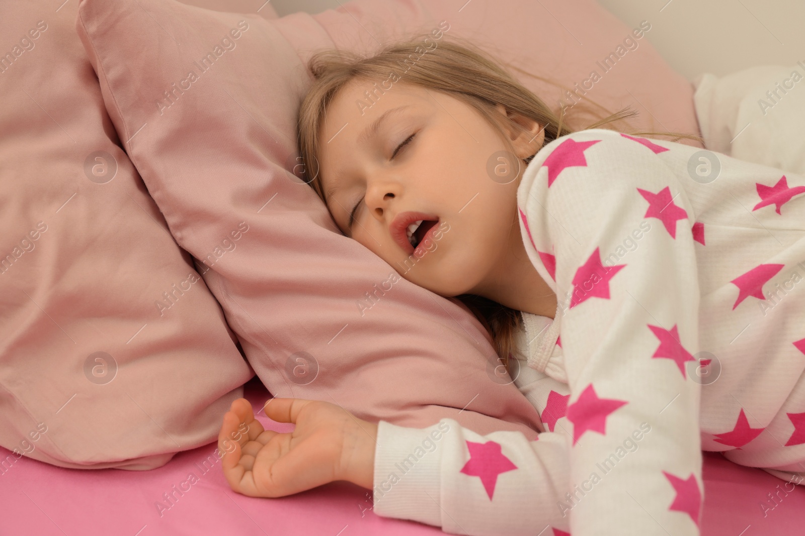 Photo of Little girl snoring while sleeping in bed