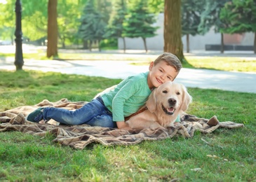 Photo of Cute little child with his pet in green park