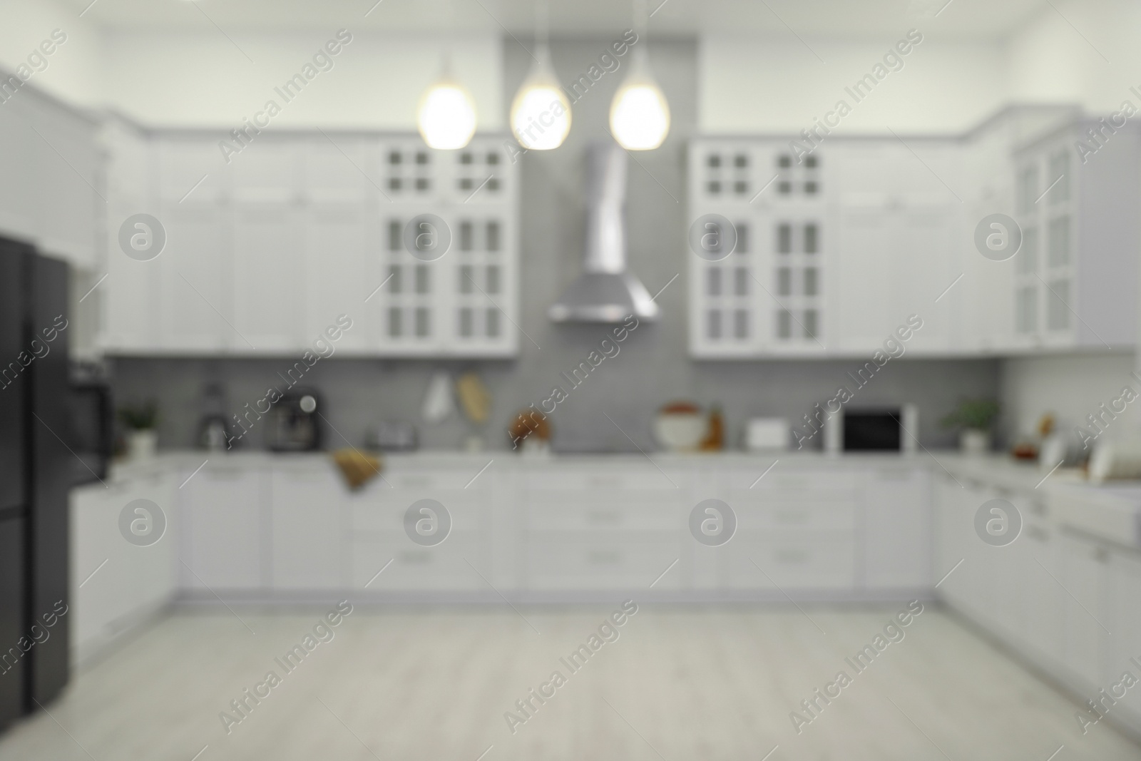 Photo of Stylish spacious kitchen with furniture, blurred view. Interior design