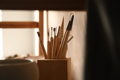 Photo of Set of different clay crafting tools in workshop, closeup