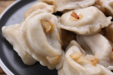 Photo of Delicious dumplings (varenyky) with potatoes and onion on plate, closeup